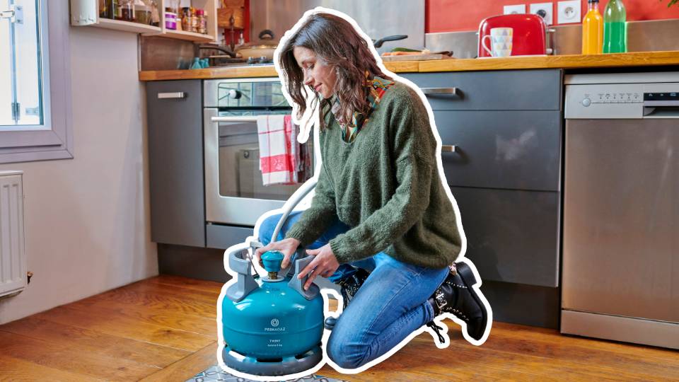 femme qui utilise une bouteille de gaz butane Twiny pour utiliser sa gazinière