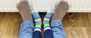 4 pieds et chaussettes collés à un radiateur au gaz connecté au chauffage central de la maison
