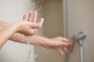 femme utilise chauffe eau bouteille de gaz pour prendre sa douche