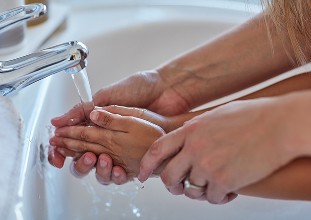 Deux personnes qui se lavent les mains à l'eau chaude apportée par une chaudière au gaz propane